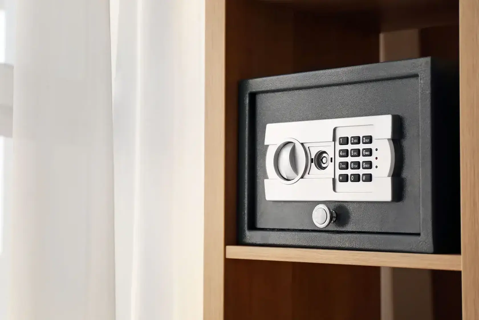Kleine kluis met elektronisch cijferslot in een houten kast